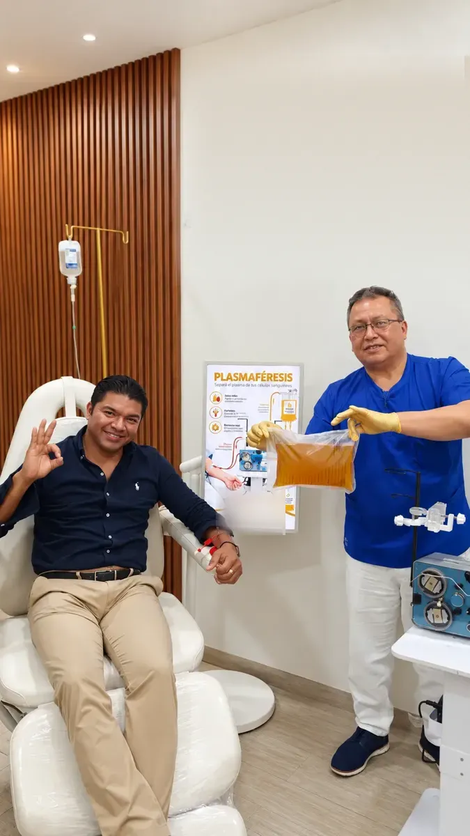 Physician shows a bag of collected plasma beside a seated patient in a clinical room