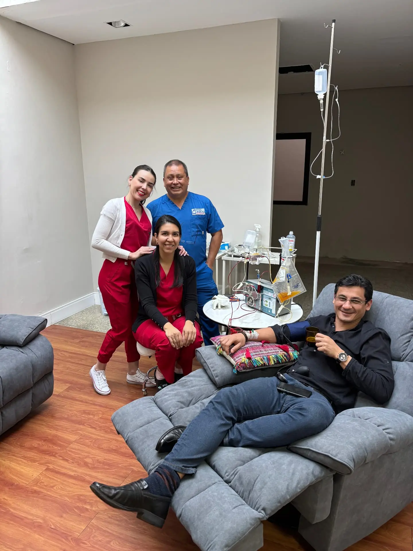 Patient undergoing treatment in a NexusMed clinical room accompanied by three health professionals